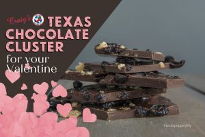Texas Pepper Jelly Chocolate cluster in broken pieces on table and pink hearts in corner of image